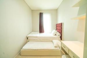 Dos camas en una habitación pequeña con ventana. en Spacious 2BR Near Mall Thamrin, SCBD, en Yakarta