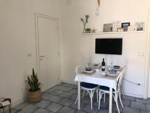 a white dining room with a white table and chairs at Casa Laura a due passi dal mare in Rimini