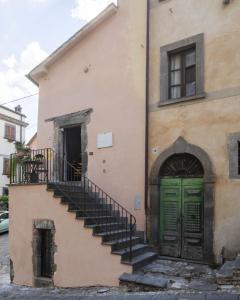 an old building with a green door and stairs at Civitella Relais in Civitella dʼAgliano