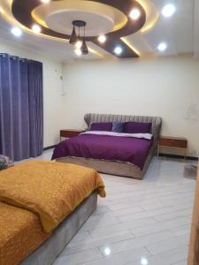 a bedroom with two beds and a ceiling at Cottage in Changla Gali - Secluded, Cozy Stay in Chhāngla Gali