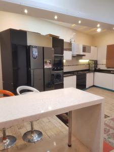 a kitchen with black and white appliances and a table at Cottage in Changla Gali - Secluded, Cozy Stay in Chhāngla Gali