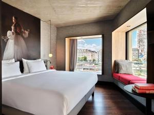 Un dormitorio con una gran cama blanca y una ventana. en Radisson RED Hotel, Vienna, en Viena