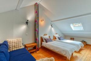 a attic room with two beds and a couch at Lumières du Lac in Lugrin