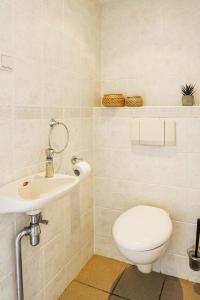 a bathroom with a toilet and a sink at Private Seaside Room High-speed Wi-fi in Zoutelande