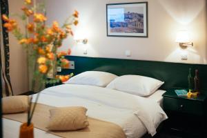 a bedroom with a large white bed with a green headboard at Ignatia Hotel in Nafplio