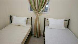 two beds sitting next to each other in a room at villa by the sea in Kato Alepochori