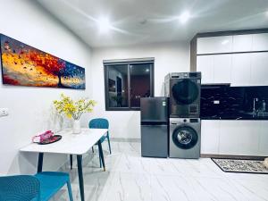 a kitchen with a washing machine next to a table at Phương house in Long Biên +12 photos