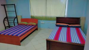 two beds sitting next to each other in a room at Ayurora home in Dambulla +2 photos