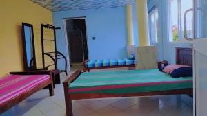a room with two beds and two chairs in it at Ayurora home in Dambulla
