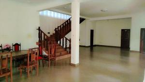 a dining room with a table and wooden stairs at Ayurora home in Dambulla