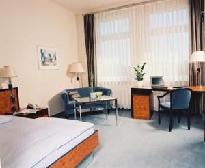 a living room filled with furniture and a table at Hotel Arkadia in Friedrichsdorf