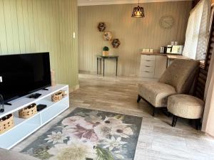 a living room with a flat screen tv and two chairs at Casa Madeira 3 in Everton 