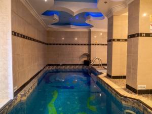a swimming pool in a hotel room with a large tub at Hotel Arca lui Noe in Sinaia