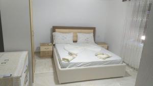 a bedroom with a white bed with a mirror at Vila Ansi Klean in Udënisht