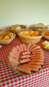 a plate of meat and fruit on a table at Refúgio Rio do Boi in Praia Grande