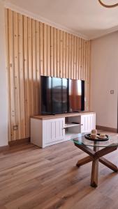 Una sala de estar con un televisor de pantalla plana en un centro de entretenimiento. en Luxury apartment, en La Tejita