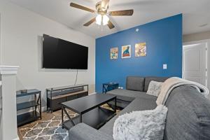 a living room with a couch and a flat screen tv at Branson Fun Zone Dog-Friendly Games Pool in Branson