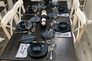 a black table with black plates and wine glasses at Branson Fun Zone Dog-Friendly Games Pool in Branson