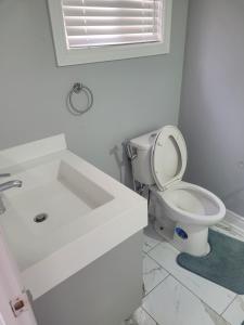 a white bathroom with a toilet and a sink at individual home in Brampton