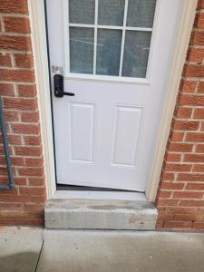 a white door on a brick building with a step at individual home in Brampton