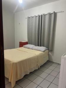a bedroom with a bed with curtains and a tiled floor at Apartamento Icaraí prox ao cumbuco in Caucaia +8 photos
