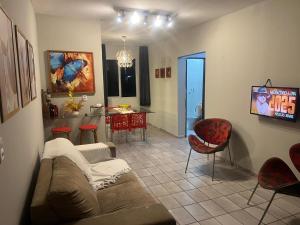 a living room with a couch and a kitchen at Apartamento Icaraí prox ao cumbuco in Caucaia