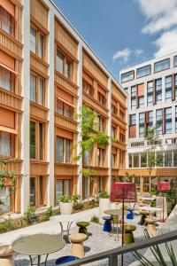 a courtyard with tables and chairs and buildings at TRIBE Paris Pantin in Pantin