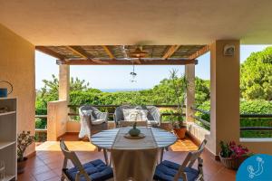 a patio with a table and chairs on a balcony at La Bouganville - House with garden and sea view in Geremèas