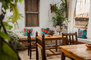a room with a table and chairs and windows at Emerald Palm Boutique Hotel in Zanzibar City