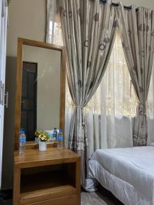 a bedroom with a bed and a mirror and a window at Comfort home in Msaranga