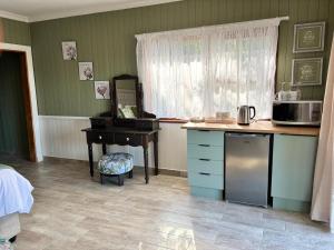 a kitchen with a sink and a desk with a microwave at Casa Madeira 4 in Everton 