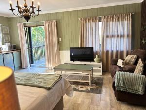 a living room with a bed and a tv and a couch at Casa Madeira 4 in Everton 