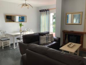 Una sala de estar con un sofá de cuero y una mesa. en Piso el Zorro, 40m2 Dachterrasse, en Istán