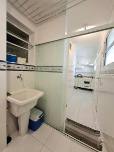 a white bathroom with a sink and a shower at Pitangueiras - Shopping in Guarujá +29 photos