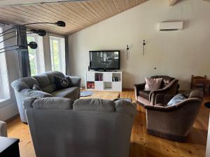 a living room with two couches and a tv at Strandvägen 6B Stig in Järvsö