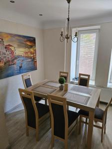 a dining room table with chairs and a painting on the wall at Summer Lounch in Liepāja