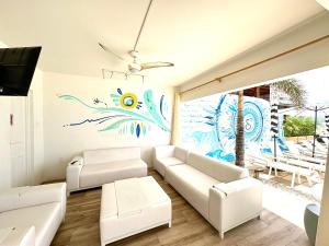 菲利普斯堡Seaview Beach Hotel的客厅配有白色家具和墙上的绘画