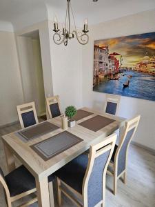 a dining room table with chairs and a painting on the wall at Summer Lounch in Liepāja