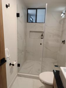 a white bathroom with a shower and a toilet at Apartamento tranquilo y familiar in Xochitepec +7 photos
