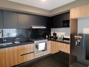 a kitchen with black cabinets and a stove at Apartamento tranquilo y familiar in Xochitepec