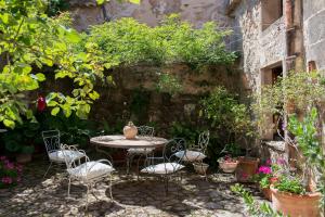 Un patio con mesa y sillas y plantas. en Finca Son Ru, en Deià