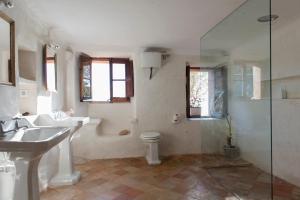 Un baño con dos lavabos y una ducha y un inodoro. en Finca Son Ru, en Deià