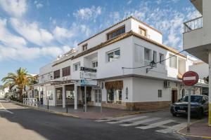 a white building on the corner of a street at Apartamentos Almadraba in Zahara de los Atunes