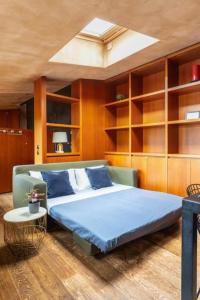 a bedroom with a bed with blue sheets and a skylight at Appartamento di design a Brera AC, Wi-Fi e lusso in Milan