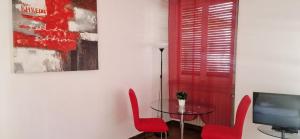a dining room with red chairs and a glass table at ROSSO MAGENTA - Luminoso loft in centro e a due passi dalla stazione in Turin