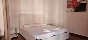 a bedroom with a bed with white sheets and two tables at ROSSO MAGENTA - Luminoso loft in centro e a due passi dalla stazione in Turin