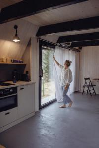 a woman is standing in a kitchen with a window at Chatička Artoa in Ludvíkov