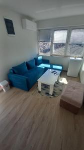a living room with a blue couch and a table at SKY Apartments in Kruševo
