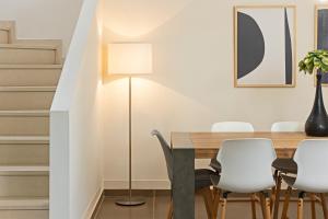 a dining room with a table and white chairs at Amare Luxury Living in Volos