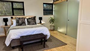 a bedroom with a bed and a window and a closet at Blue Gum Tree Cottage in Dagbreek